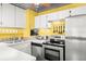 Well-lit kitchen featuring stainless steel appliances, white cabinetry, and patterned backsplash at 2610 58Th S St, Gulfport, FL 33707