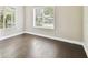 Sunlit bedroom featuring hardwood floors, a large window, and base molding for a classic look at 2708 N Mitchell Ave, Tampa, FL 33602