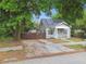 Inviting home features mature trees, a front porch, solar panels, and a gated driveway at 2708 N Mitchell Ave, Tampa, FL 33602