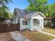 Charming home with a welcoming porch, solar panels, well-manicured lawn, and gated driveway at 2708 N Mitchell Ave, Tampa, FL 33602