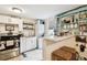Cozy kitchen featuring white cabinets, quartz countertops, stainless steel appliances, breakfast bar, and stacked washer/dryer at 2708 N Mitchell Ave, Tampa, FL 33602