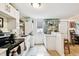 Bright kitchen featuring white cabinets, stainless steel appliances, stacked washer/dryer, and breakfast bar with seating at 2708 N Mitchell Ave, Tampa, FL 33602