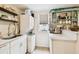 Well-lit kitchen featuring white cabinets, an open window, stainless steel appliances, and a stacked washer/dryer unit at 2708 N Mitchell Ave, Tampa, FL 33602