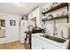 View of the kitchen featuring wood floors, stainless steel appliances, and white cabinets with long, sleek countertops at 2708 N Mitchell Ave, Tampa, FL 33602