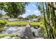 Lush backyard featuring a wooden bridge over a serene pond, enhancing the property's charm at 2779 Diane Ter, Clearwater, FL 33759