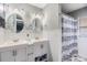 Clean bathroom with double sinks, white cabinets, modern mirrors, and a shower-tub combo at 2779 Diane Ter, Clearwater, FL 33759