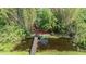 Aerial view of a backyard pond with a wooden bridge, offering a secluded and peaceful retreat at 2779 Diane Ter, Clearwater, FL 33759