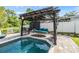 Relaxing pergola with shaded seating offers a backyard retreat by the sparkling pool at 2779 Diane Ter, Clearwater, FL 33759