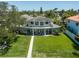 Expansive home features a large balcony, lush backyard, and direct waterfront access at 3 Paradise Ln, Treasure Island, FL 33706