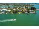 Aerial view of waterfront homes along canals, featuring private docks and boat, plus views of the bay at 3 Paradise Ln, Treasure Island, FL 33706