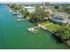 Aerial view of waterfront property with private dock and boat lift, showcasing luxury coastal living at 3 Paradise Ln, Treasure Island, FL 33706