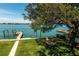 Waterfront property featuring a lush lawn, seating area, and serene water views at 3 Paradise Ln, Treasure Island, FL 33706