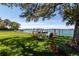 Beautiful waterfront backyard featuring lush lawn, a fire pit, and direct water access at 3 Paradise Ln, Treasure Island, FL 33706
