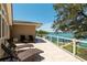 A beautiful outdoor area featuring stylish lounge chairs and glass railings with stunning views of the water at 3 Paradise Ln, Treasure Island, FL 33706