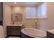 A beautifully designed bathroom features a soaking tub, custom cabinets, and plantation shutters at 3 Paradise Ln, Treasure Island, FL 33706