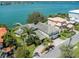 A luxurious house exterior shows professional landscaping, large lawn, and easy access to water at 3 Paradise Ln, Treasure Island, FL 33706