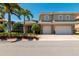Beautiful two-story home with a paver driveway, tropical landscaping, and a spacious two-car garage at 3 Paradise Ln, Treasure Island, FL 33706