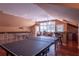 Spacious game room with a ping pong table, bar area, and stunning water views from large windows at 3 Paradise Ln, Treasure Island, FL 33706