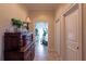 Hallway with decorative wood dresser and greenery, leading to a brightly lit room at 3 Paradise Ln, Treasure Island, FL 33706