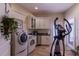 Well-equipped laundry room with modern washer, dryer, and utility sink at 3 Paradise Ln, Treasure Island, FL 33706