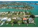 Aerial view of waterfront neighborhood, homes with docks, and lush landscaping. Features access to the bay at 3 Paradise Ln, Treasure Island, FL 33706