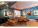 A cozy media room with a large sectional sofa, movie posters, and entertainment setup at 3 Paradise Ln, Treasure Island, FL 33706