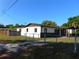 Single-story home with a charming covered front porch, fenced yard, and long driveway at 3002 W Haya St, Tampa, FL 33614