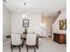 Light-filled dining room featuring a wooden table set for four, with a staircase in the background at 32094 Pop Ash Pl, San Antonio, FL 33576