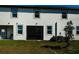 A rear exterior view of the townhome with an enclosed patio and well-maintained lawn at 32094 Pop Ash Pl, San Antonio, FL 33576