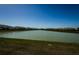 Scenic view of a lake surrounded by townhomes and lush green grass at 32094 Pop Ash Pl, San Antonio, FL 33576