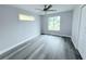 Bedroom featuring laminate floors, a ceiling fan, and large windows at 3329 Roxbury Dr, Holiday, FL 34691