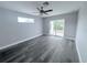 This bedroom has gray wood floors, a ceiling fan, sliding glass doors and lots of natural light at 3329 Roxbury Dr, Holiday, FL 34691