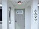 Front entry door with a light gray finish and small window at 3329 Roxbury Dr, Holiday, FL 34691
