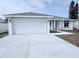 Newly constructed home featuring a large two-car garage and freshly poured concrete driveway at 3329 Roxbury Dr, Holiday, FL 34691