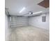 An empty one car garage with a concrete floor and a bright overhead light at 3329 Roxbury Dr, Holiday, FL 34691