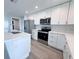 Modern kitchen boasts white cabinets, stainless steel appliances, and quartz countertops at 3329 Roxbury Dr, Holiday, FL 34691