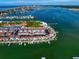 A beautiful aerial view of waterfront townhomes and boat docks on a sunny day with recreational facilities at 343 Rex Pl # G, Madeira Beach, FL 33708