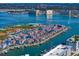 Wide aerial view of townhomes with boat docks, set against a backdrop of water and a clear blue sky at 343 Rex Pl # G, Madeira Beach, FL 33708