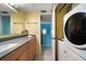 Bathroom featuring a vanity, mirror, washer/dryer, and tile flooring at 343 Rex Pl # G, Madeira Beach, FL 33708
