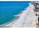 A scenic view of a white sand beach with blue water and a few people enjoying the sun at 343 Rex Pl # G, Madeira Beach, FL 33708