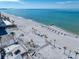 A serene coastal scene with a sandy beach dotted with palm trees and beach amenities at 343 Rex Pl # G, Madeira Beach, FL 33708
