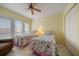 Bright guest bedroom with twin beds, ceiling fan, shuttered windows, and tile flooring at 343 Rex Pl # G, Madeira Beach, FL 33708
