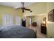 Bright main bedroom featuring a bed, tile flooring, fan, furniture and shuttered windows at 343 Rex Pl # G, Madeira Beach, FL 33708