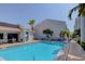 Community swimming pool with lounge chairs and a clubhouse on a clear day at 343 Rex Pl # G, Madeira Beach, FL 33708