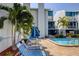 Community swimming pool with lounge chairs and tropical landscaping at 343 Rex Pl # G, Madeira Beach, FL 33708