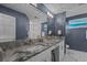 Modern bathroom featuring dual sinks, granite countertops, and a decorative seascape art piece at 380 Palmdale Dr, Oldsmar, FL 34677