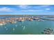 Expansive aerial view showcasing a waterfront community with lush landscapes, sailboats, and sparkling blue waters at 400 Island Way # 201, Clearwater Beach, FL 33767