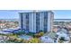 A striking view of a modern, high-rise condo building, featuring a pool and covered parking at 400 Island Way # 201, Clearwater Beach, FL 33767