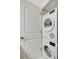 The laundry room boasts stacked white washer and dryer, and white door at 400 Island Way # 201, Clearwater Beach, FL 33767