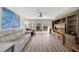 A comfortable living room featuring a large TV, modern furniture, and floor-to-ceiling windows at 400 Island Way # 201, Clearwater Beach, FL 33767